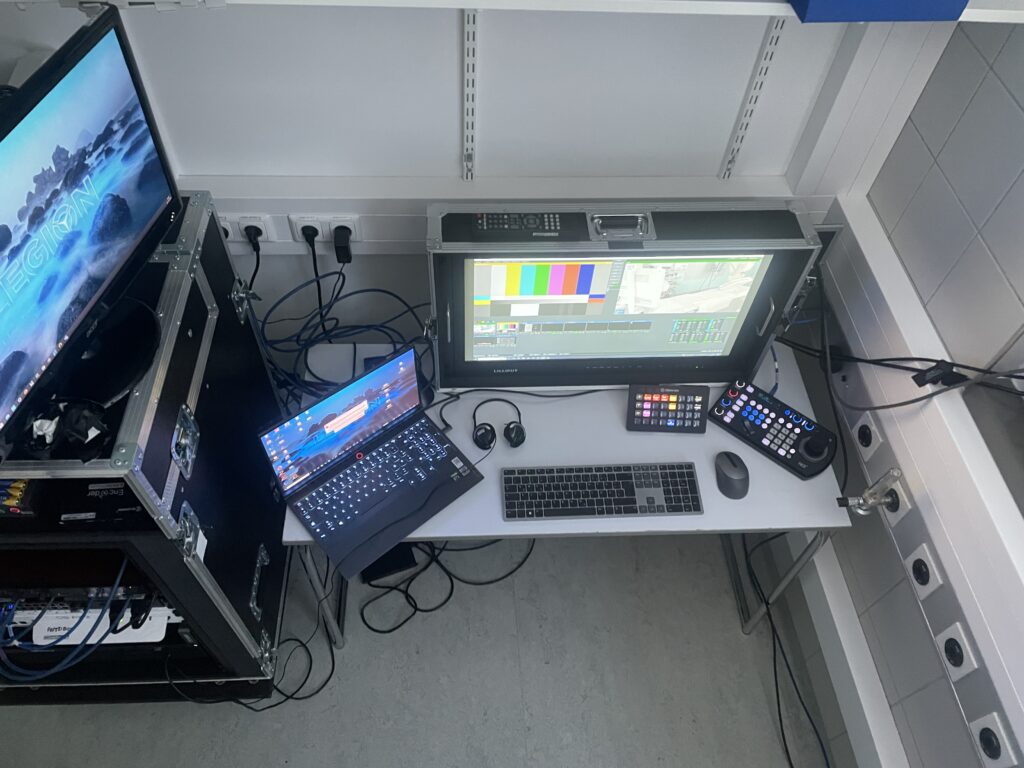 Control position from above: monitor in a flight case with video mixing software, laptop, camera controller and keyboard